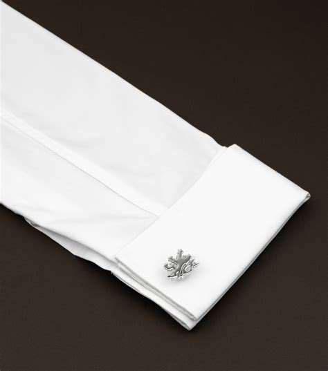 Detailný záber na manžetové gombíky v tvare malých sudov na whisky