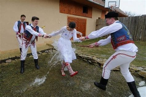 Mladý muž šibe dievča korbáčom na Veľkonočný pondelok