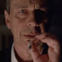 muž pijící alkohol a kouřící cigaretu