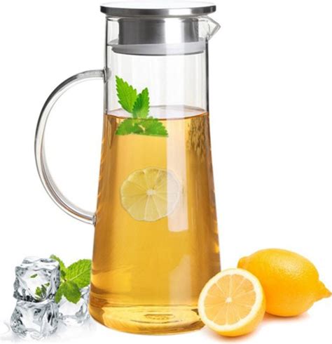 Sklenený džbán s bielym vínom a vedľa neho pohár s vodou