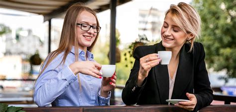 Mladí ľudia popíjajúci kávu v mestskej kaviarni