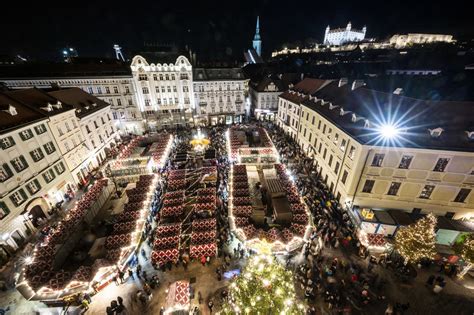 Ilustračná fotografia vianočných trhov s drevenými stánkami a svetelnou výzdobou