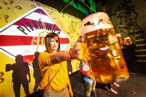 Ilustračná fotografia osoby nosiacej pivnú helmu s plechovkami