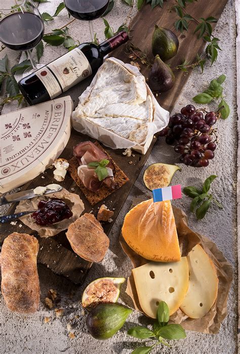 Tanier s rôznymi druhmi francúzskych syrov a pohárom červeného vína