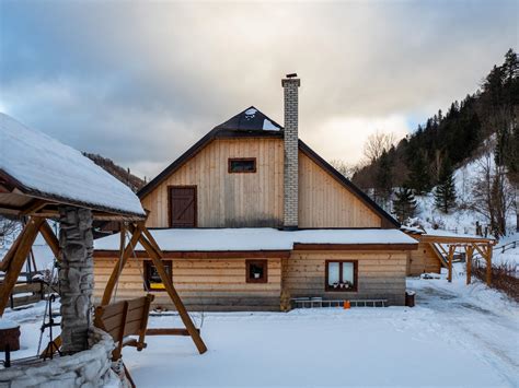 Tradičná slovenská drevená chalupa s fľašou domácej pálenky