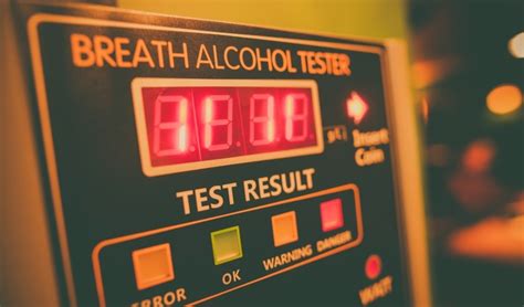 Ilustrácia muža fúkajúceho do alkohol testera