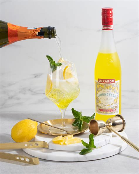 Fľaša Luxardo Limoncello na stole s citrónmi v pozadí