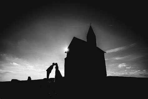 Pár sa drží za ruky vo vinohrade pri západe slnka