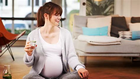 žena s bruškom si vychutnáva pohár