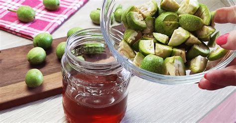 Ruka v rukaviciach krájajúca zelené orechy