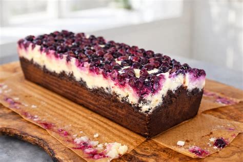 Fľaša domáceho čučoriedkového likéru s rumom obklopená čerstvými čučoriedkami a badiánom