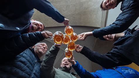 Ľudia sledujú súťaž v pití piva na ex