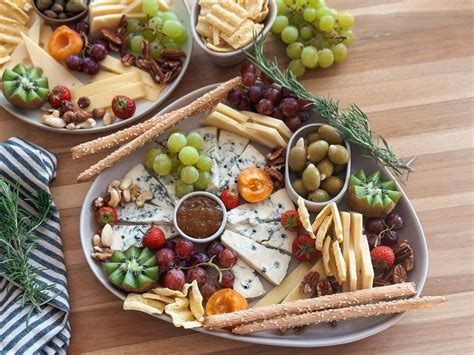 Tanier s rôznymi druhmi syrov a pohár Chardonnay