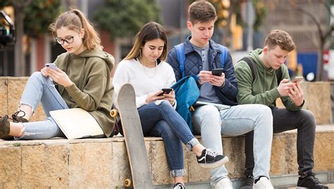 Mladí ľudia s mobilnými telefónmi