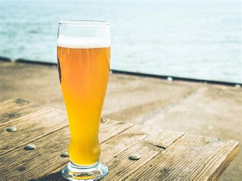 Zlatisté pivo v pohári s bohatou penou