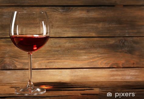 Pohár červeného vína Merlot s detailom dreveného sudu