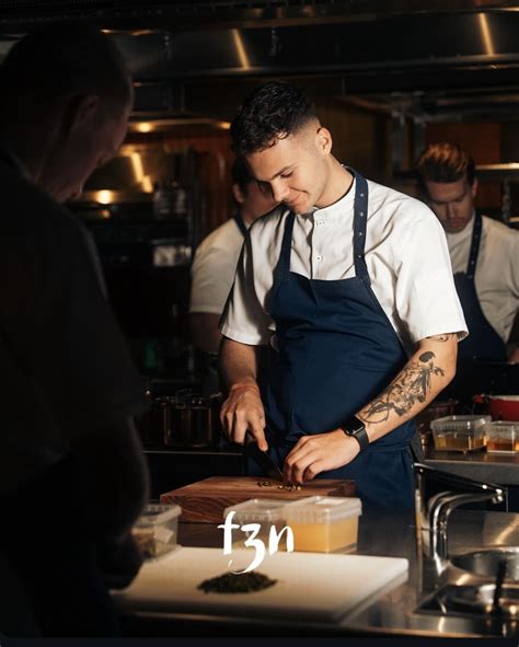 Mladý kuchár flambuje jedlo na panvici