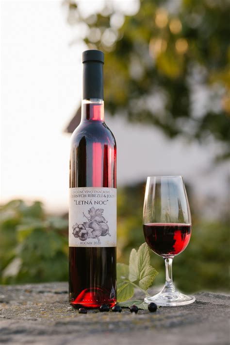 Fľaša vína z čiernych ríbezlí s pohárom