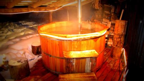 Osoba relaxuje v drevenej kadi s pivom