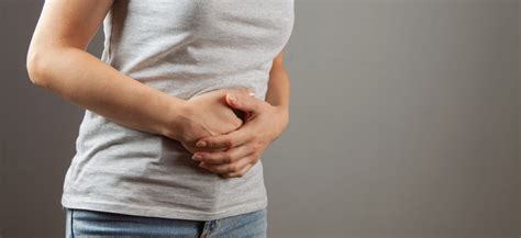 žena držiaca brucho v ruke